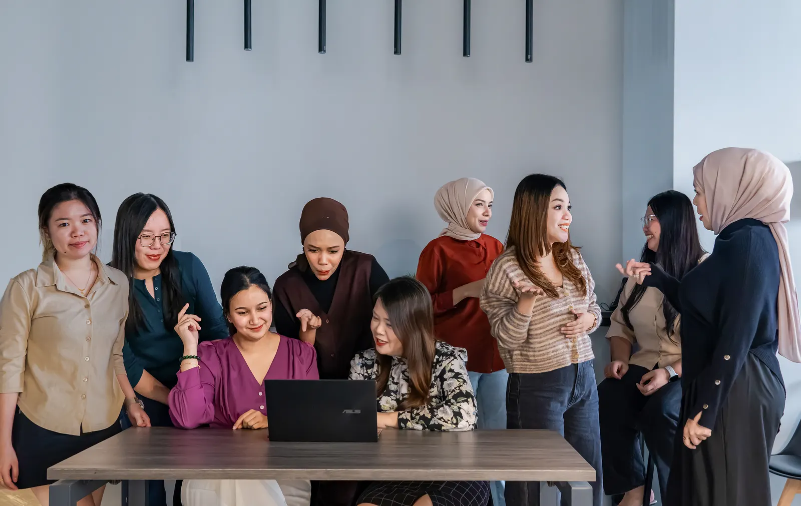 Colleagues gathered at a laptop, mid-discussion